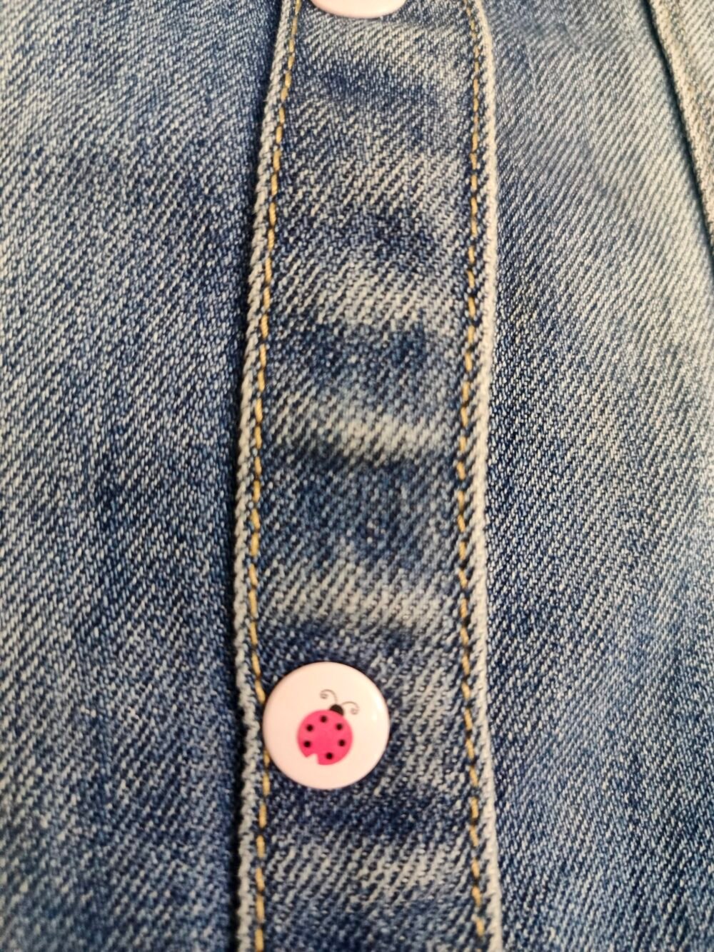 stylish light-wash denim jacket featuring playful sleeve graphic with ladybug cute buttons - Image 3