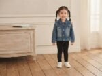 stylish light-wash denim jacket featuring playful sleeve graphic with ladybug cute buttons